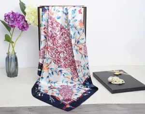 Details von blauen Blumen und Schmetterlingsmustern auf weißem Satin-Halstuch