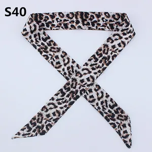 Detailed view of leopard print twilly silk scarf tied in a cross with pointed ends