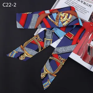 Detail of a silk scarf with equestrian horse stirrup patterns on a deep blue background