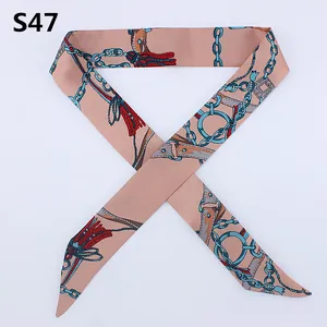 Detailed shot of slim silk scarf with blue chain patterns and elegant tapered ends