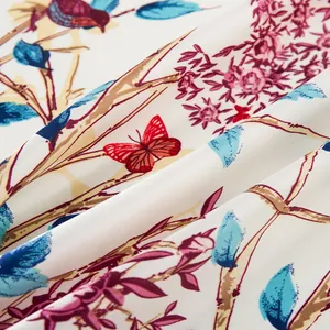 Makro-Detail des Seidenschals mit eleganten Blumenmustern, blauen Vögeln und Schmetterlingen