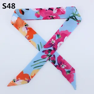 Macro shot of light blue floral skinny scarf with pink flowers for bag handle decoration