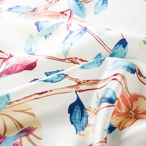 Detail eines Seidensatintuchs mit Blumen-Vogel-Muster und eleganten blauen Blättern