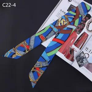 Detail of blue silk twilly scarf with equestrian print wrapped around bag handle
