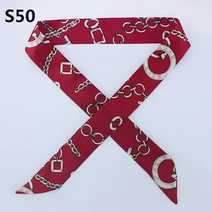 Detail of red satin skinny scarf with gold chain pattern and Paris text print
