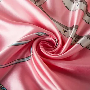Detail of pink silk-like scarf featuring equestrian chain print and satin luster finish