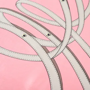 Macro detail of the silk scarf featuring vintage chain belt patterns and gold eyelets