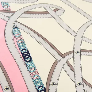 Macro view of the silk scarf featuring fine stitching and chain patterns on high-quality fabric