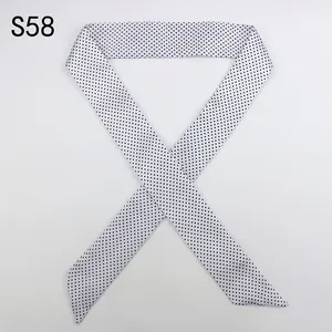 Detailed view of long skinny scarf with classic black and white polka dot pattern