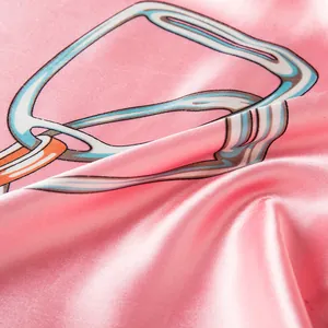 Macro view of silky pink satin scarf with artistic blue and orange abstract patterns