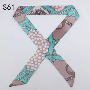 Detailed view of long satin twilly scarf with mint green and pink retro chain patterns