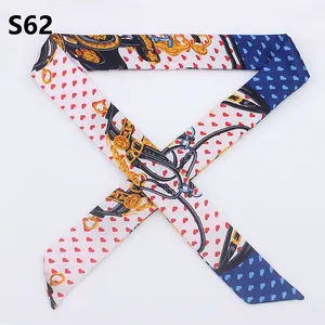 Close-up of a printed twilly scarf with heart and equestrian motifs on a white background