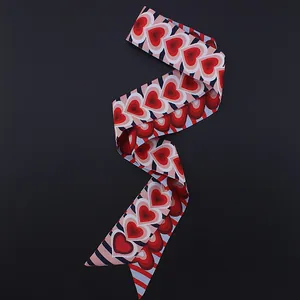 Detalle de bufanda de seda con estampado de corazones y corte diagonal en negro