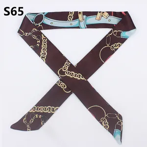 Detail of elegant slim silk twilly scarf featuring chain and leather strap pattern