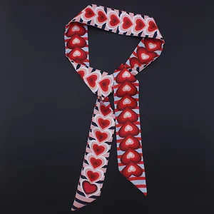 Vista detallada del pañuelo de seda a rayas de 120cm con estampados de corazones y textura