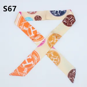 Detailed view of long twilly silk scarf with carriage pattern for handbag handle wrap
