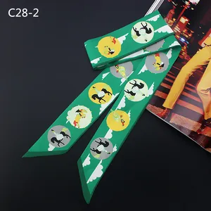 Detail of green silk scarf with carousel horse prints next to a fashion magazine