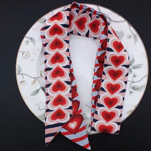 Detalle de corazones rojos en bufanda de seda a rayas sobre un plato de flores vintage