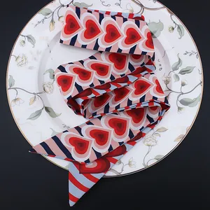 Pañuelo de seda de 120 cm con corazones y rayas sobre un plato de porcelana floreado
