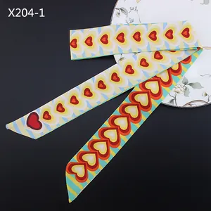 Primer plano de un pañuelo twilly de 120 cm con patrones de corazones sobre tela de satén
