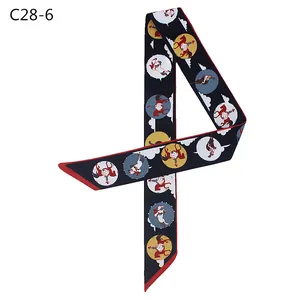 Navy blue silk twilly scarf with equestrian print and red trim displayed on white background