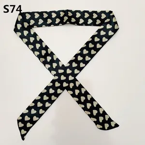 Close-up of black satin twilly scarf with cream heart print for handbag handles