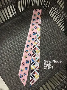 Gros plan d'un foulard twilly rose nude aux motifs floraux et géométriques sur osier