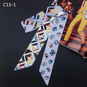 Détail d'un foulard étroit en soie à motif floral et géométrique avec bouts en biais