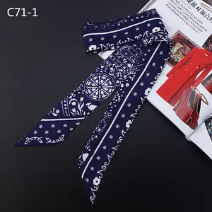 Detail of navy blue bohemian skinny scarf with white floral patterns on a dark background
