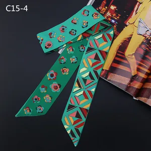 Vue détaillée d'un foulard en soie à fleurs et motifs géométriques sur fond texturé noir