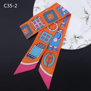 Twilly en soie orange avec motifs géométriques de boucles et pointes de couleur rose