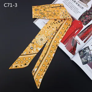 Close-up of yellow silk twilly scarf with black mandala prints and geometric borders