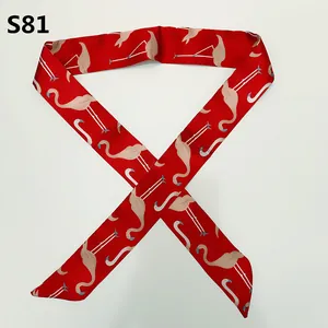 Macro detail of red satin silk scarf with pink flamingo pattern for handbag handles