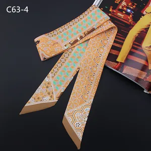 Macro detail of silk-feel Twilly scarf with warm orange geometric and floral patterns