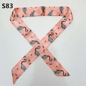 Detail of pink satin scarf featuring gray flamingo patterns and a silky texture