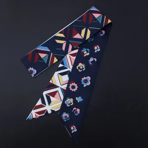 Gros plan d'un foulard étroit en soie à fleurs et motifs géométriques sur fond noir