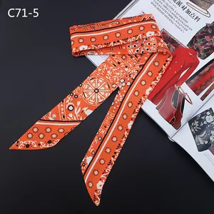 Detail of bohemian orange silk twilly scarf with intricate prints on fashion magazine