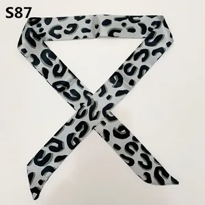 Detailed view of silver satin skinny scarf with dark grey leopard print and angled tips