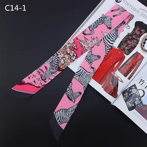 Detail van roze satijnen twilly sjaal met zebraprint als elegant accessoire voor tas