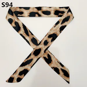 Detail of slim satin ribbon scarf featuring a classic leopard print pattern in earth tones