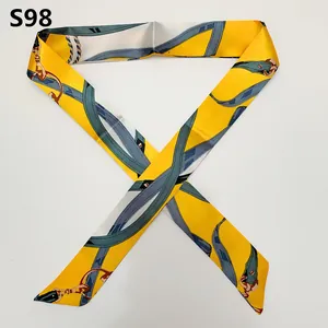 Macro detail of satin twilly scarf with yellow and blue equestrian harness pattern