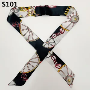 Detail view of retro twilly silk scarf with gold chain and red knot patterns on white silk