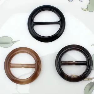 Close-up of three marble-patterned resin scarf rings for waist and scarf adjustment
