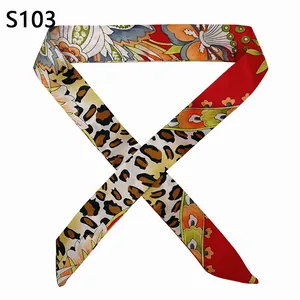 Detail of a red floral and leopard print narrow silk scarf wrapped for handbags
