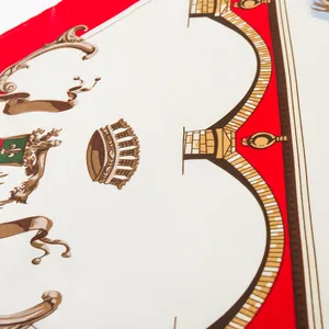 Detailed close-up of premium silk scarf featuring royal crest patterns and crown designs