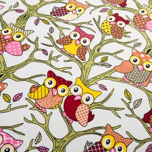 Detail of silk scarf with colorful cartoon owl patterns on vibrant branches