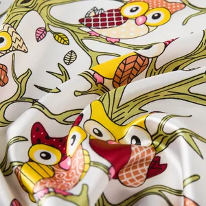 Detailed close-up of colorful cartoon owl pattern on satin silk scarf fabric