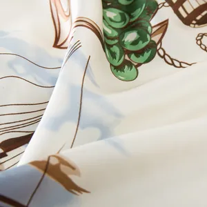 Close-up of silk-satin scarf fabric with sailing ship and green grape pattern