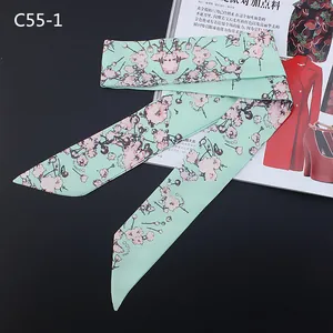Detail of mint green floral twilly silk scarf with pink cherry blossoms for handbag handles