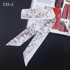 Detail of white floral skinny silk scarf with pink cherry blossoms on a black background